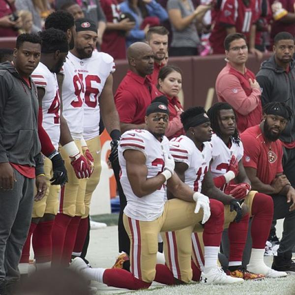Football players kneeling on the sidelines