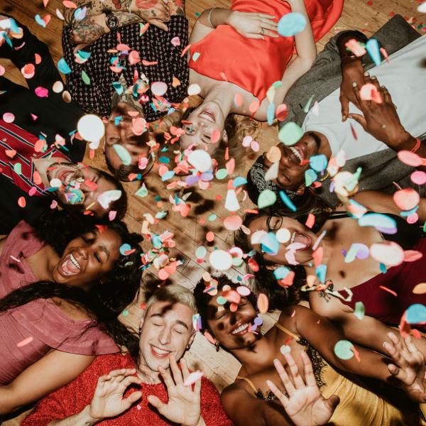Group of young people, laying in a circle on the ground at a holiday party