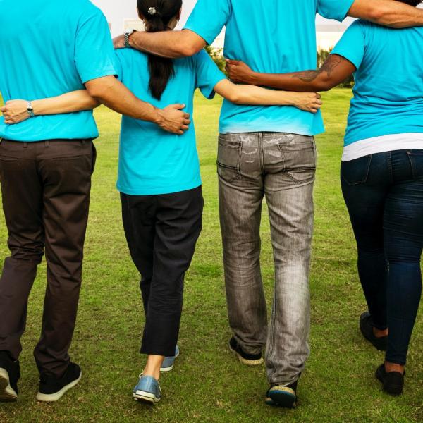 Group of people walk with arms around each other