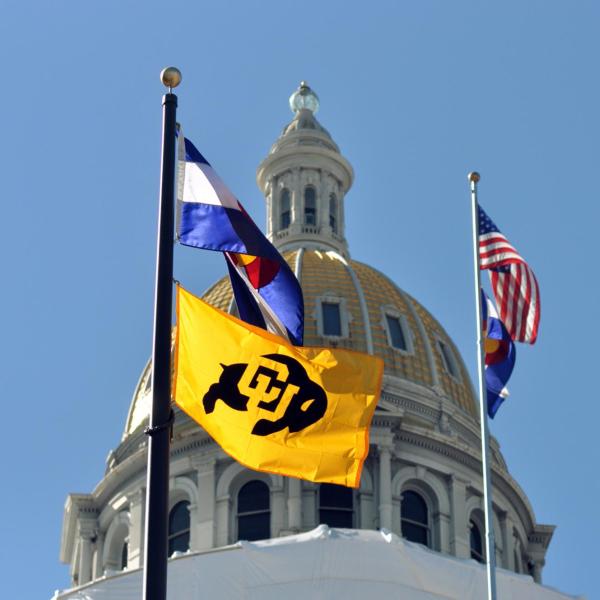 state capitol building with U.S., state and CU flags