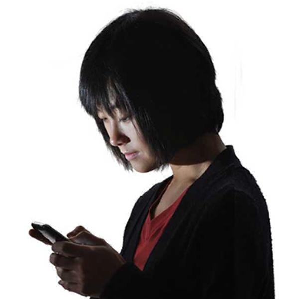 A woman looks at a message on her phone