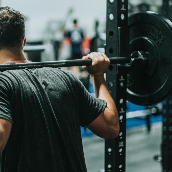 A person lifting a barbell (Photo by Andrew "Donovan" Valdivia/Unsplash)