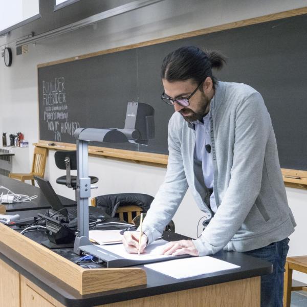 A lecturer teaching in front of a class