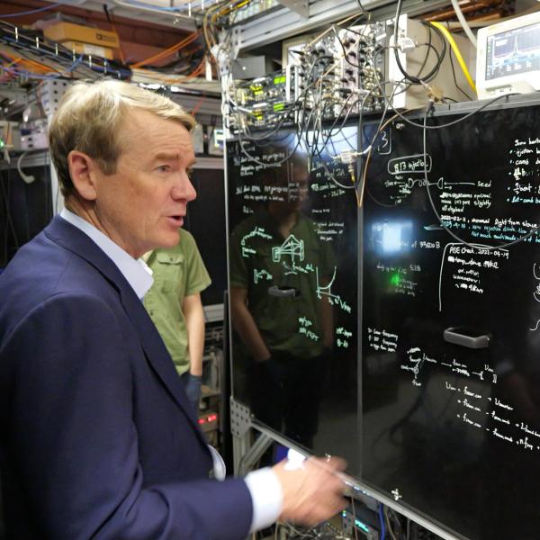 Sen. Michael Bennet visits with Jun Ye, professor adjoint and fellow, while visiting JILA