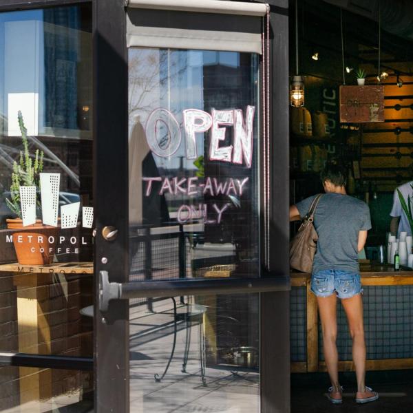 A woman at a coffee shop open to take out service in Denver, Colo.