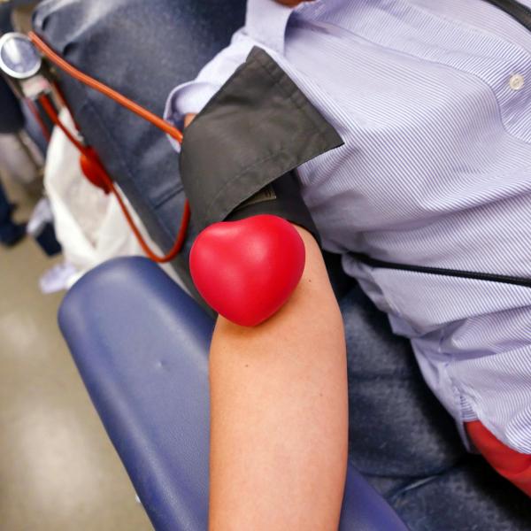 The arm of a blood donor wearing a blood pressure sleeve.