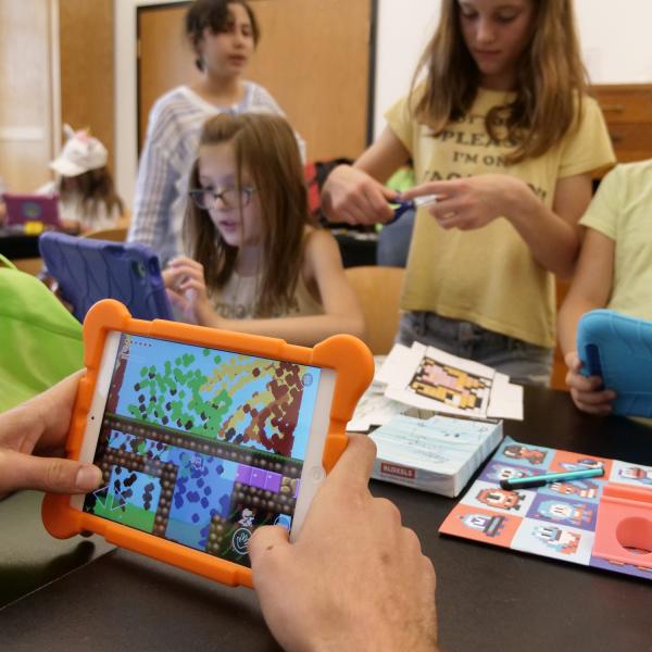 CU summer camp participants using a handheld device