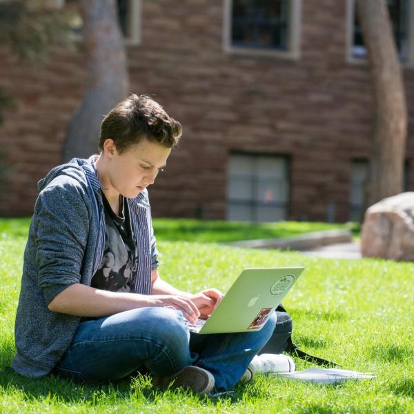 student working on laptop outside