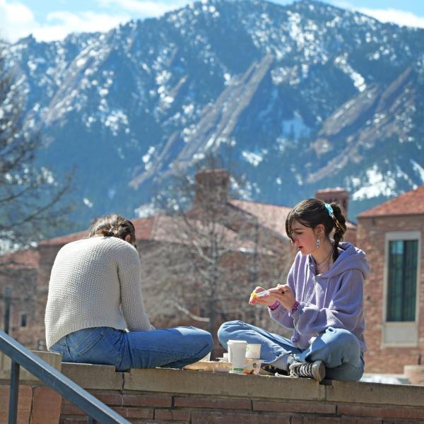 Two students eating lunch outside on campus