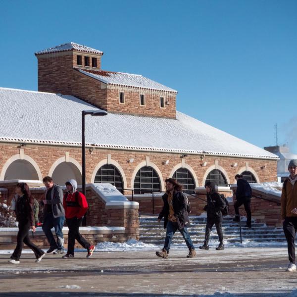 students walk across a snowy campus