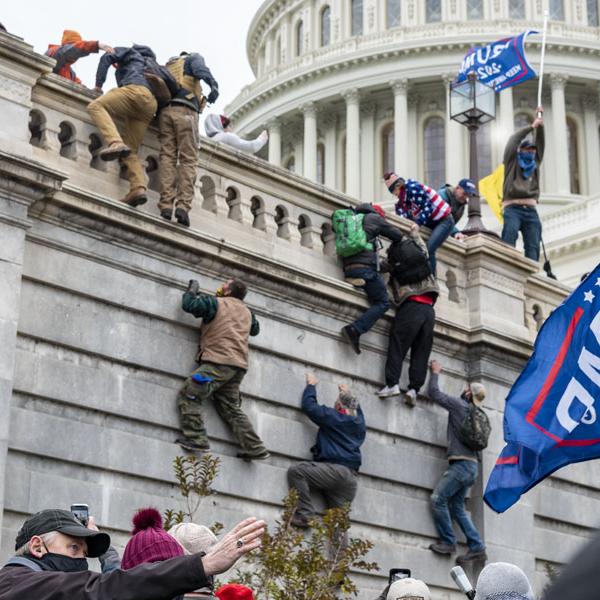 Rioters scale a wall at the Capitol on January 6, 2021. (Credit: CC image via Flickr)
