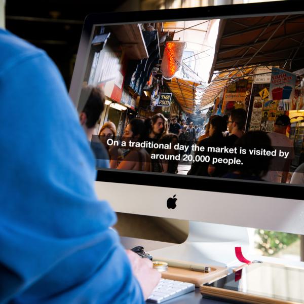 Man watches video with captions on iMac computer