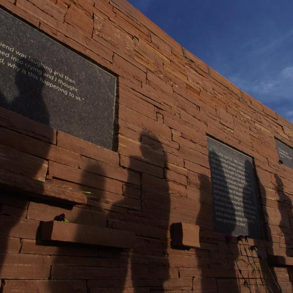 Visitors file by the inscribed plaques on the outer circle of the Columbine Memorial at Clement Park. Credit: Glenn Asakawa