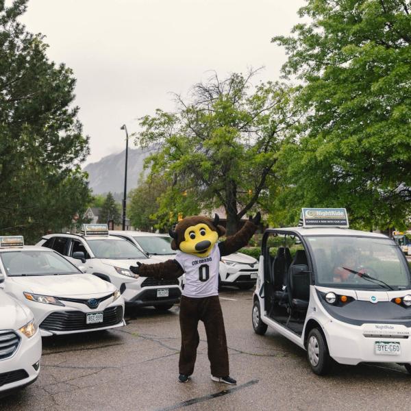 Chip the buffalo mascot poses for a photo with the CU NightRide fleet