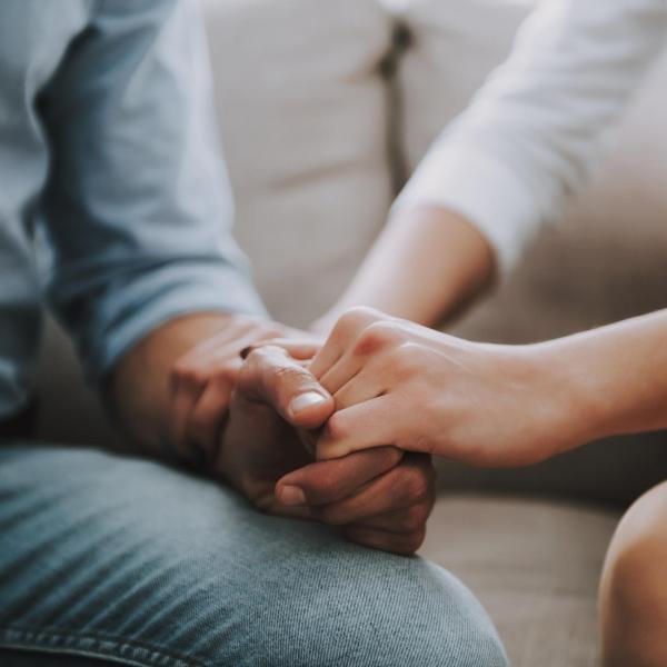 two adults holding hands