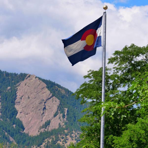 Colorado flag with Flatirons in the background
