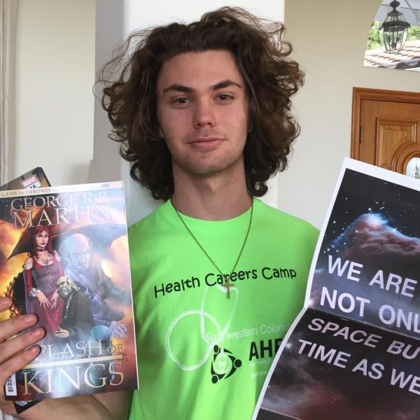 Sophomore Aristotle Bougas holds items from the care package shipped to his home.