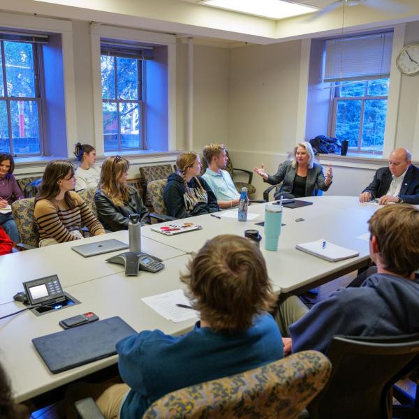 A Community Scholars Program cohort meets at a conference table.
