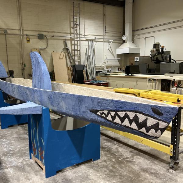 A concrete canoe in the shape of a blue shark.