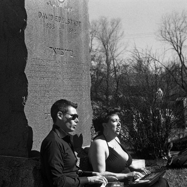 Two Archive Transformed residents sit against headstone