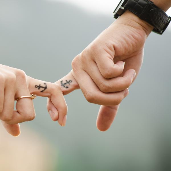 A couple holding hands with matching tattoos