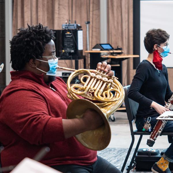 students wearing masks while playing brass and wind instruments