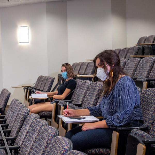 students physically distance in large lecture hall