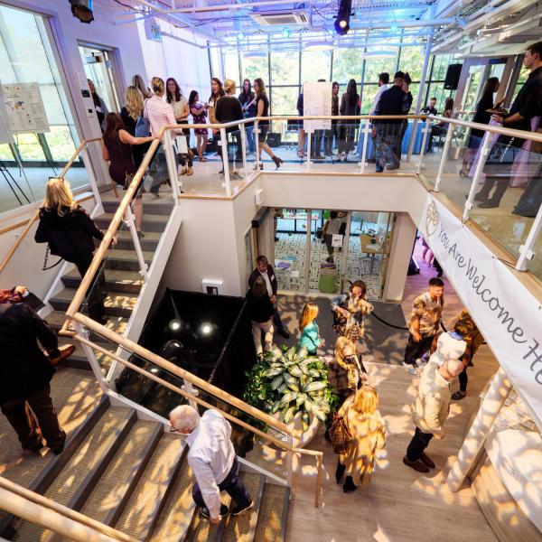 Guests mingle as a pattern of gold light filters through the atrium windows.