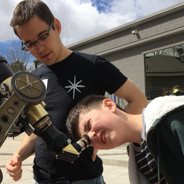 Kid looks through telescope as part of CU-STARs project