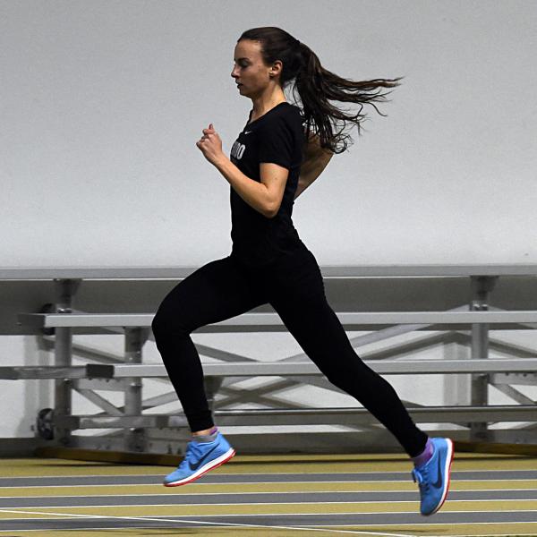 Dani Jones runs past empty bleachers