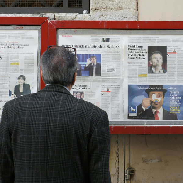 Person reading newspaper clips in a display box
