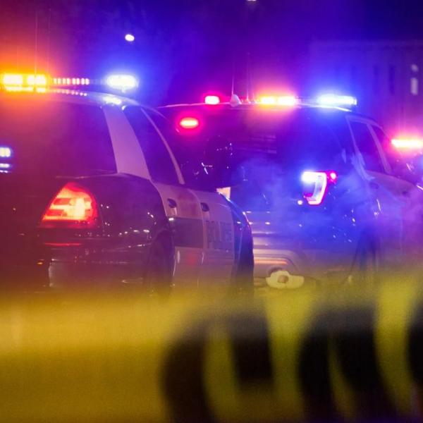 police cars behind yellow caution tape