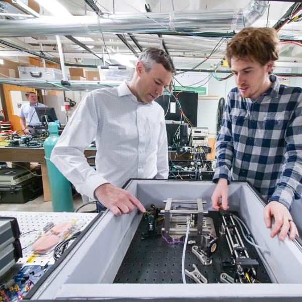 Greg Rieker (left) works with another person in a lab setting.