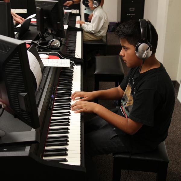 Elementary student practices during Piano for Dreamers class