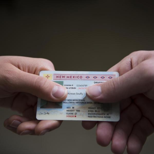 Person hands over drivers license
