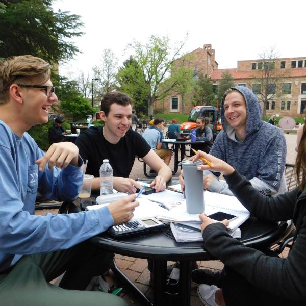 group of students studying at an outdoor table