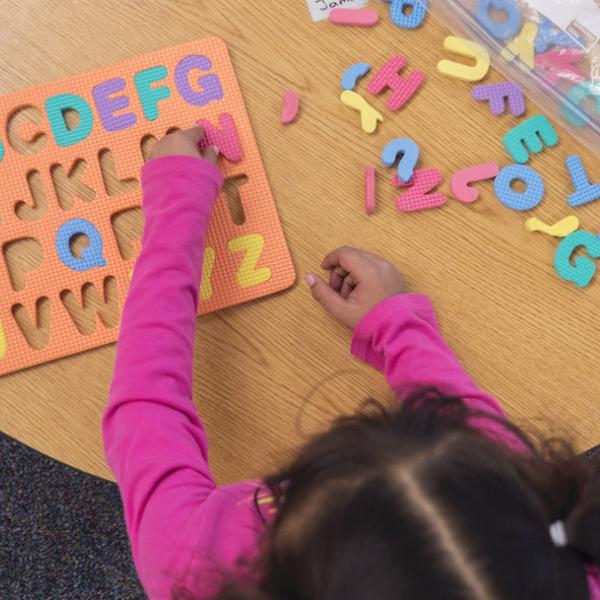 Child playing with an alphabet puzzle