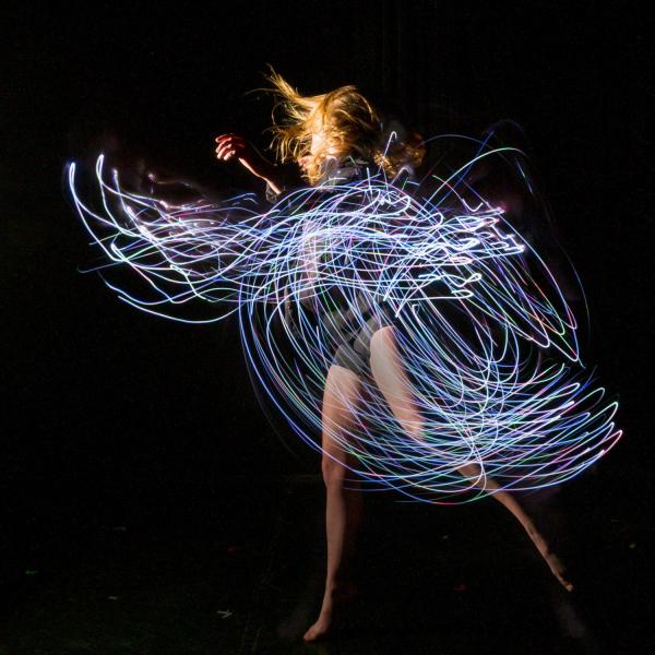 Emily Daub performs a modern dance while wearing LED-lit costume