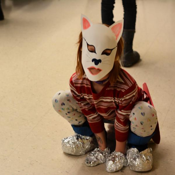 Young student dressed as feline superhero poses for photo