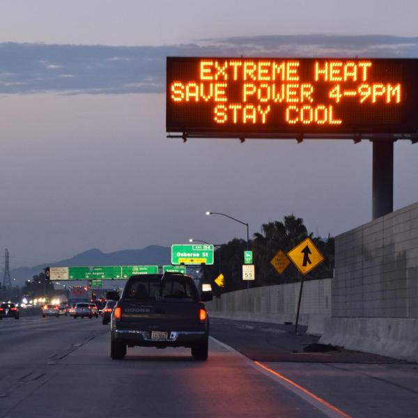 Highway road sign reads: "Extreme heat. Save power 4-9 p.m. Stay cool."