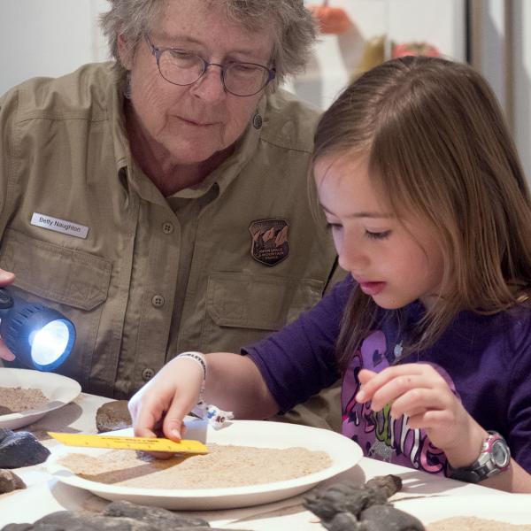 Preschooler examines dirt at a CU Museum of Natural History Family Day event