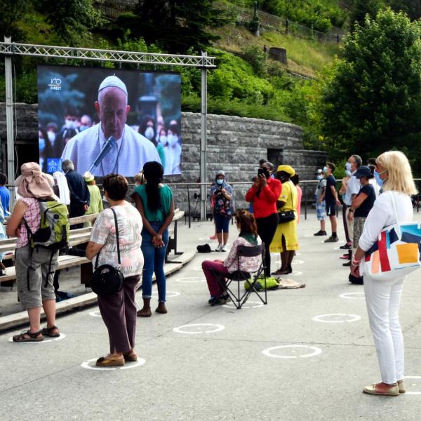 People wearing masks and social distancing at the Sanctuary of Our Lady of Lourdes
