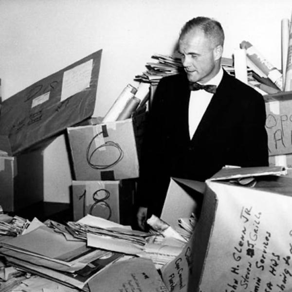 John Glenn looking through piles of mail