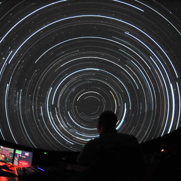 Person works controls at Fiske Planetarium's immersive theater