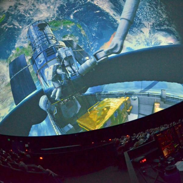 audience watching a full-dome space film at Fiske Planetarium