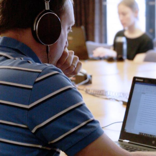 Graduate student working on computer with headphones