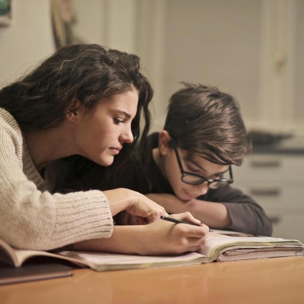 Adult helping young student with homework