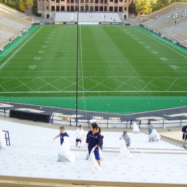 Students clean up Folsom Field after a game