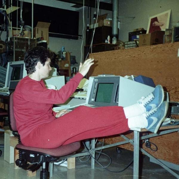Woman in red track suit puts her feet up while working on a desktop computer