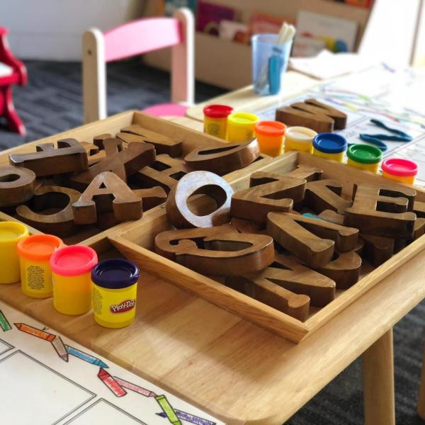 Child's table with wooden toy letters and play-doh